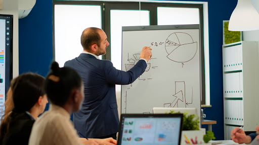 homem mostrando para a equipe indicadores financeiros